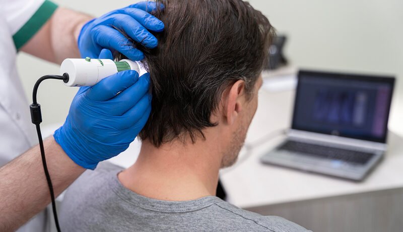 Man undergoing a professional scalp analysis for hair loss treatment.