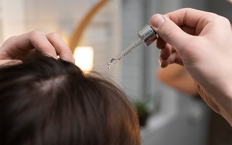 Close-up of serum being applied directly to the scalp.