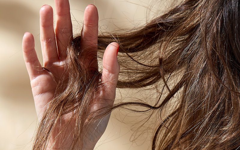 Close-up-of-woman-holding-dry-hair-ends-for-treatment