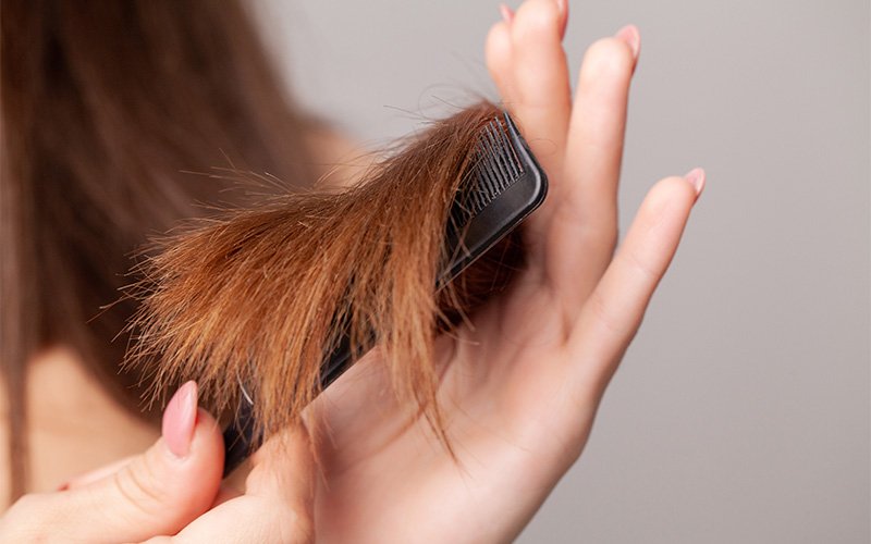 woman-combing-damaged-dry-hair-ends